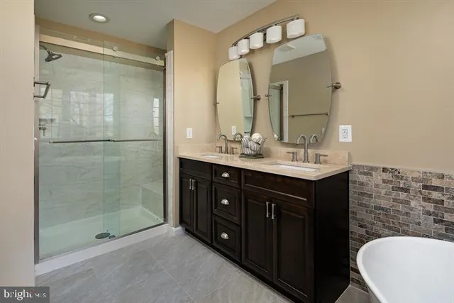 a bathroom with a double vanity sink mirror and shower