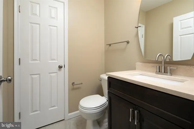 a bathroom with a granite countertop sink toilet and a mirror