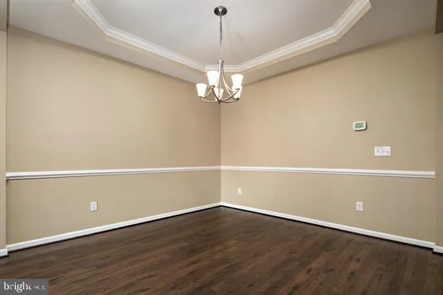 a view of a room with wooden floor and chandelier