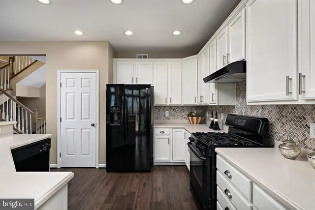 a kitchen with a refrigerator and a stove top oven