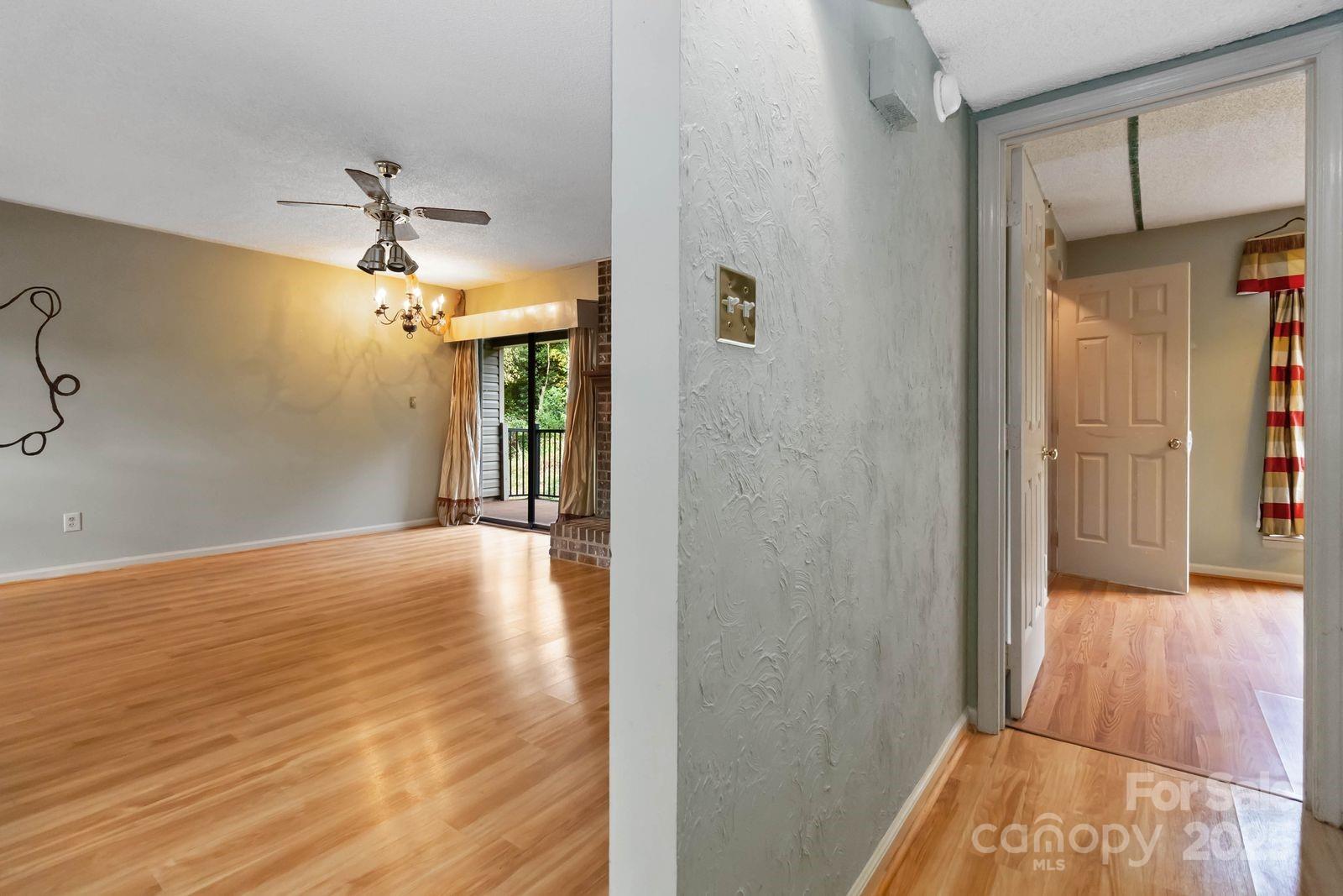 11001 Running Ridge Rd. Charlotte, NC 28226 - Photo 11 of 38 a view of a hallway with wooden floor and chandelier