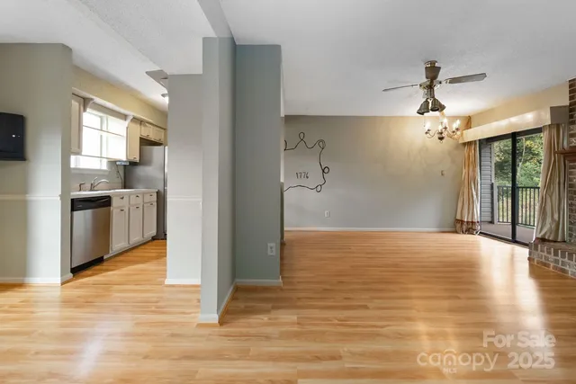 a view of a hallway with wooden floor and chandelier