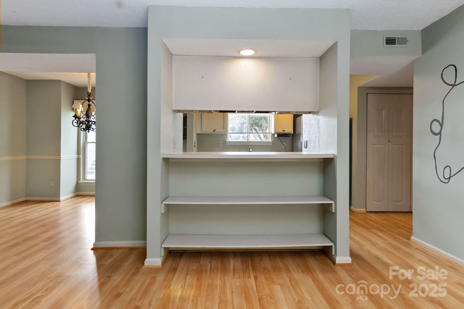 11001 Running Ridge Rd. Charlotte, NC 28226 - Photo 13 of 38 a view of a hallway with wooden floor and chandelier