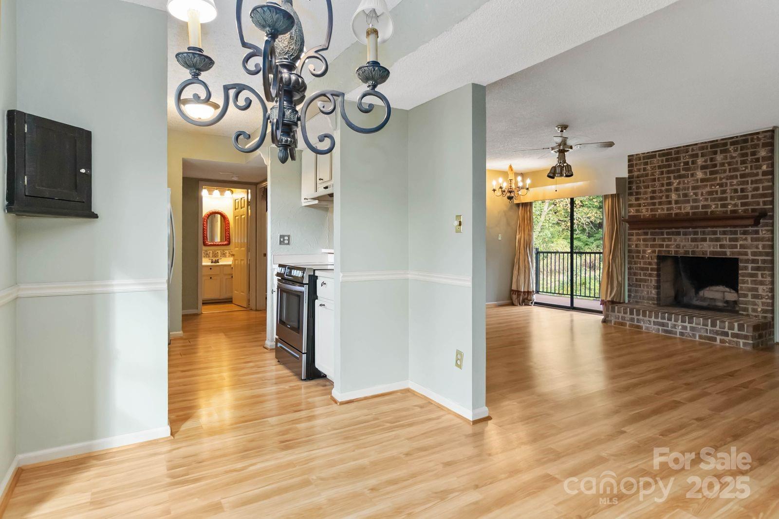 11001 Running Ridge Rd. Charlotte, NC 28226 - Photo 16 of 38 a view of a hallway with wooden floor and a kitchen