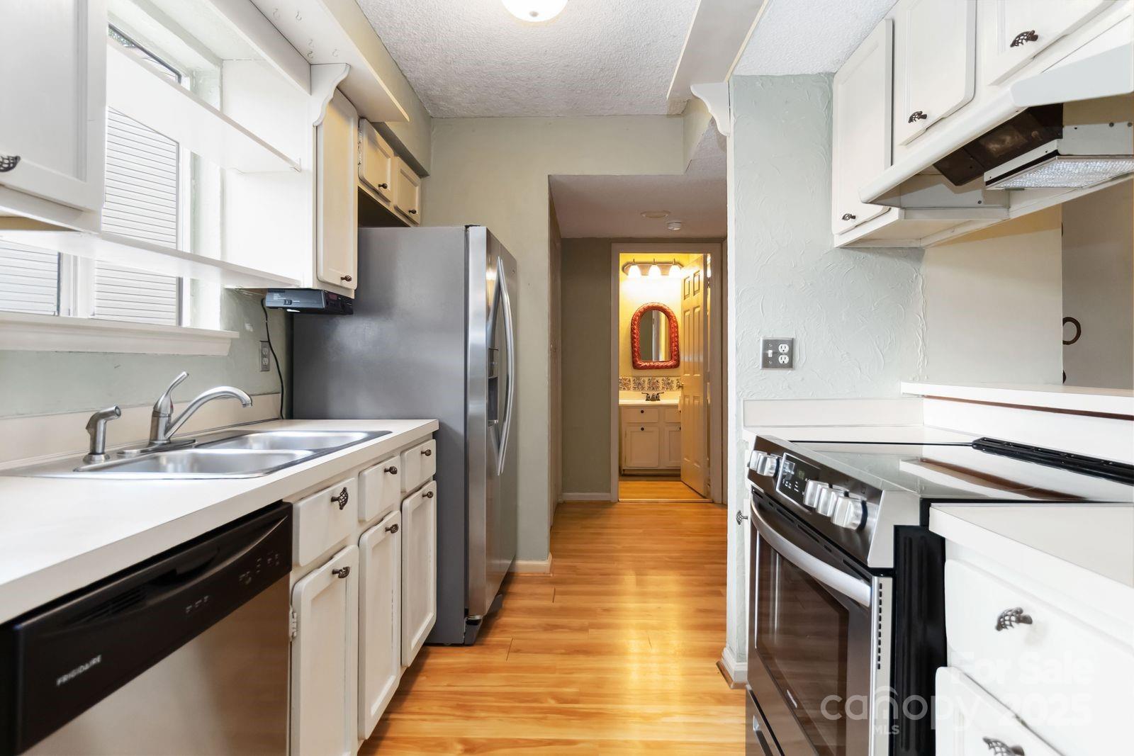 11001 Running Ridge Rd. Charlotte, NC 28226 - Photo 17 of 38 a kitchen with stainless steel appliances granite countertop a sink a stove and a refrigerator