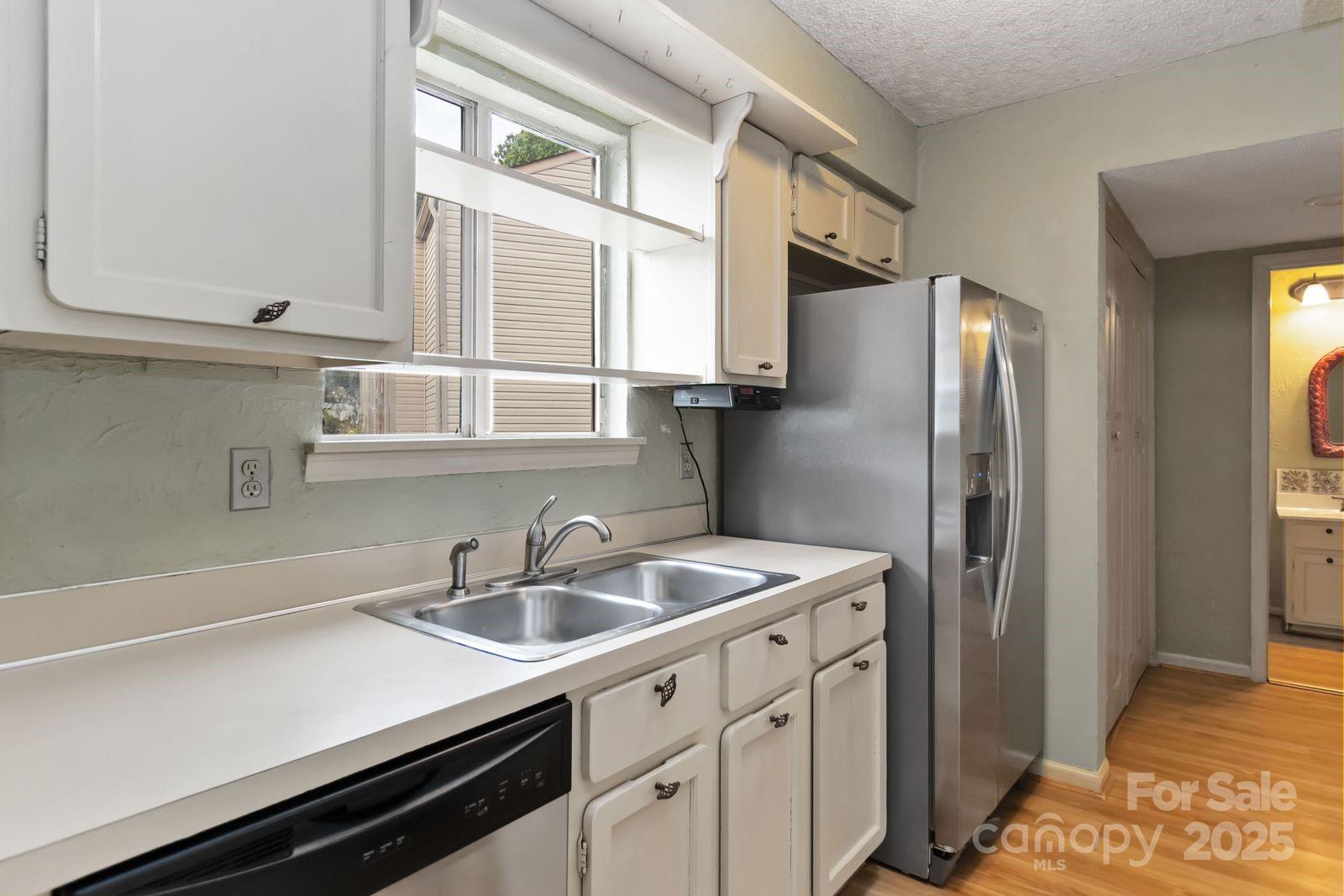 11001 Running Ridge Rd. Charlotte, NC 28226 - Photo 18 of 38 a kitchen with stainless steel appliances a sink a refrigerator and cabinets