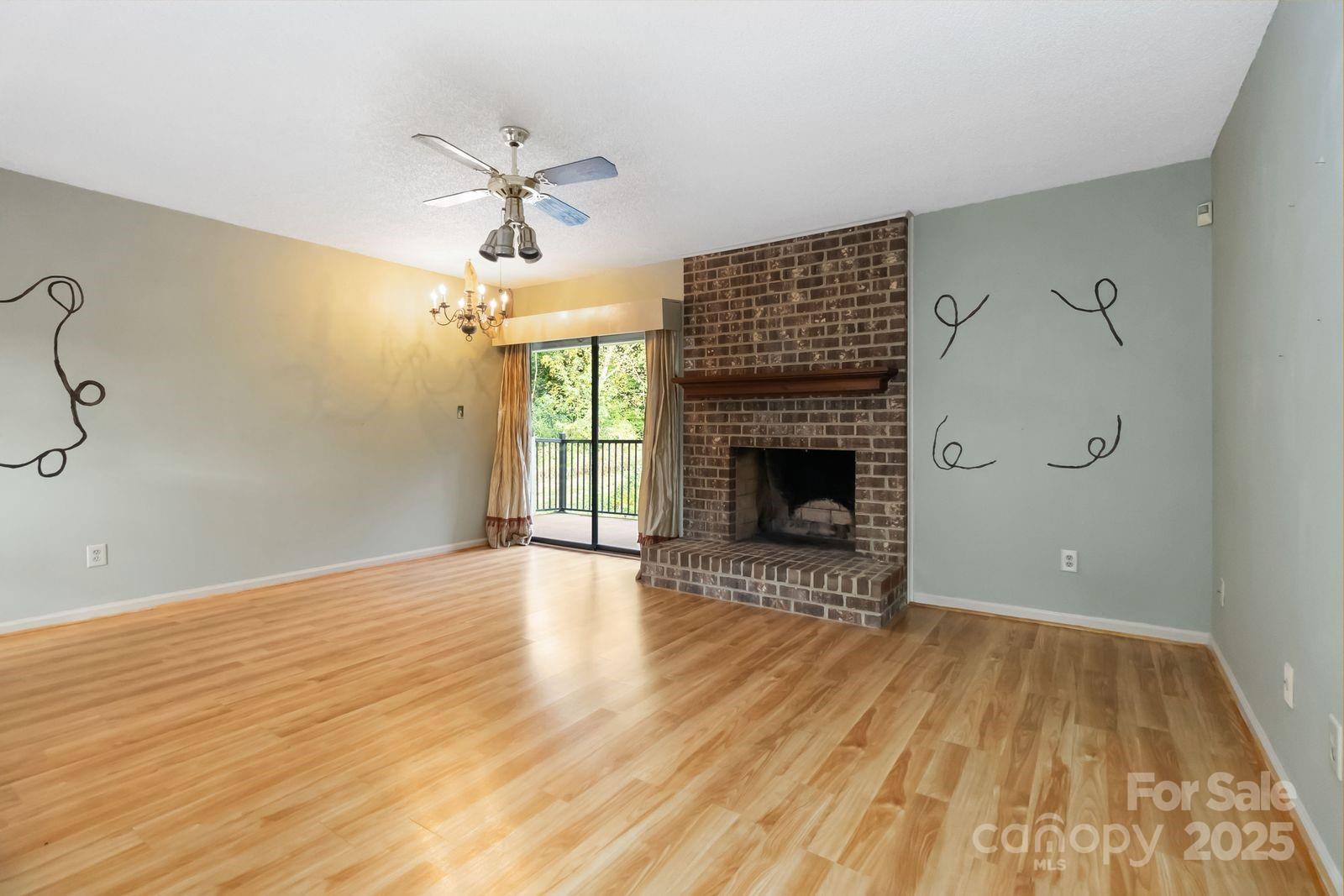 11001 Running Ridge Rd. Charlotte, NC 28226 - Photo 7 of 38 a view of an empty room with wooden floor fireplace and a window