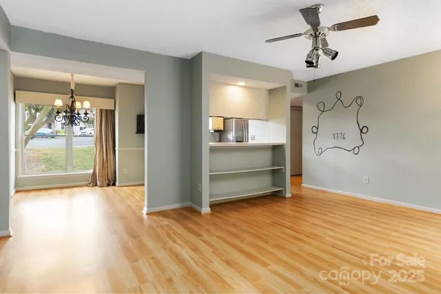 a view of a hallway with wooden floor and chandelier