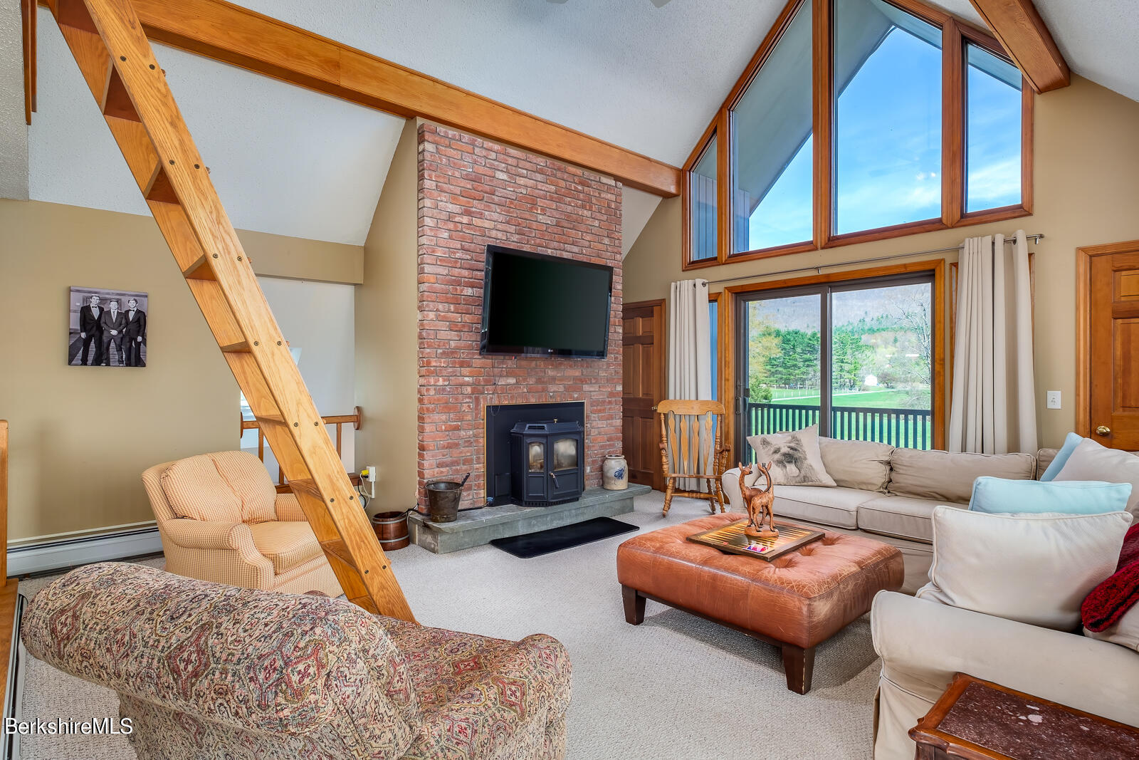 491 Henderson Road Williamstown, MA 01267 - Photo 23 of 42 a living room with furniture a fireplace and a floor to ceiling window