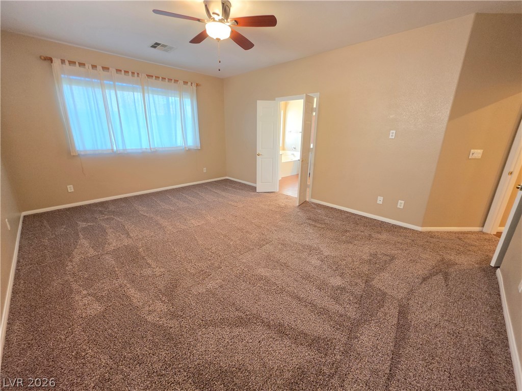209 Opera House Street Henderson, NV 89012 - Photo 33 of 45 A spacious bedroom features plush carpeting and a large window.
