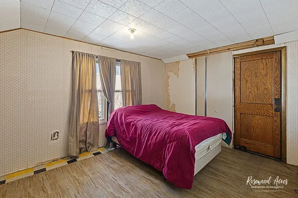 a spacious bedroom with a bed and wooden floor