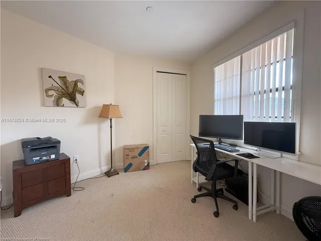 a view of a workspace with furniture and a window