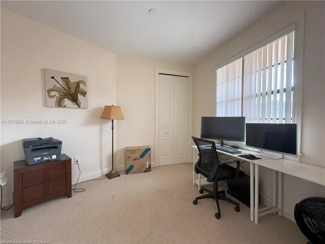 a view of a workspace with furniture and a window