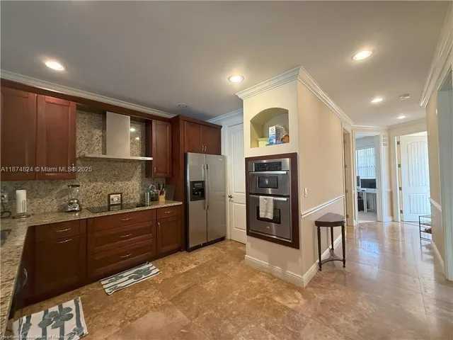 a kitchen with stainless steel appliances granite countertop a refrigerator and a stove top oven