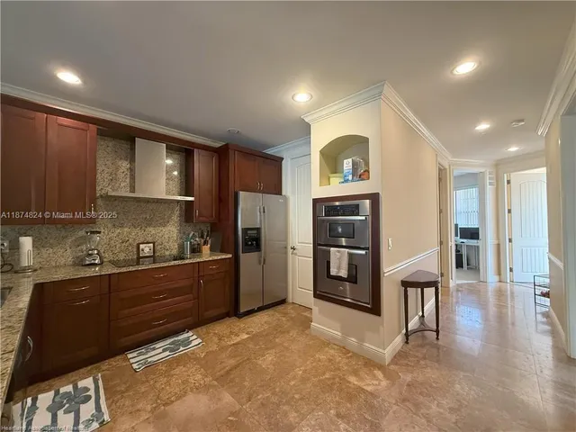 a kitchen with stainless steel appliances granite countertop a refrigerator and a stove top oven