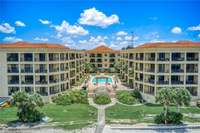 a front view of a building with a garden and plants
