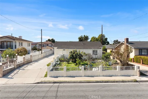 a front view of a house with a yard and potted plants
