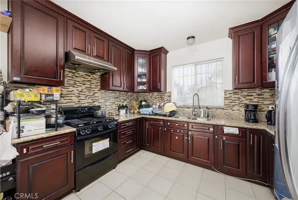 a kitchen with stainless steel appliances granite countertop wooden cabinets a stove top oven a sink and dishwasher