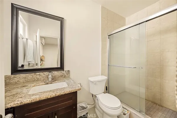 a bathroom with a granite countertop sink toilet and shower
