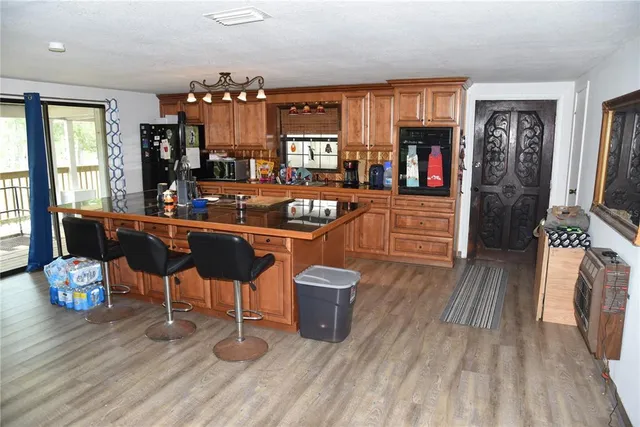 a kitchen with stainless steel appliances granite countertop a stove a dining table and chairs in it