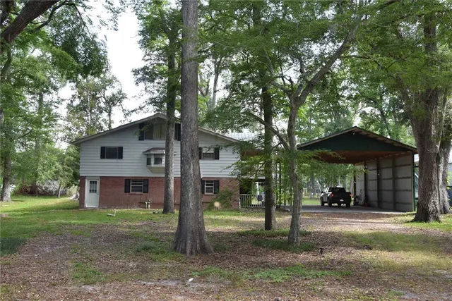 a front view of a house with a yard and tree s