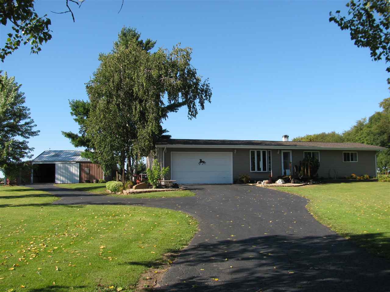 15533 Comly Rd. Pecatonica, IL 61063 - Photo 1 of 25 a front view of a house with a yard and trees