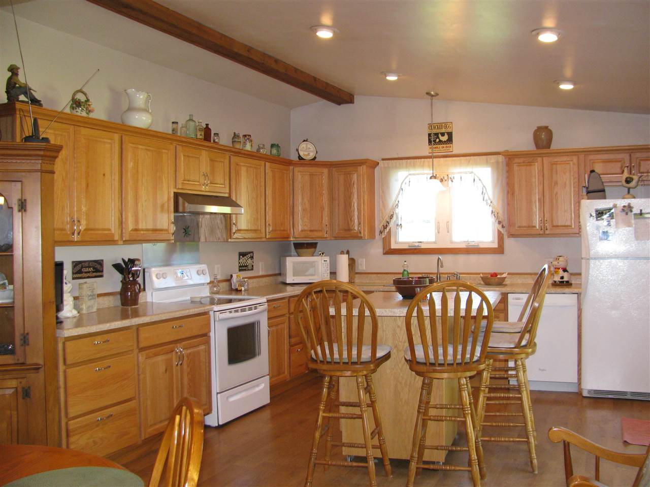 15533 Comly Rd. Pecatonica, IL 61063 - Photo 8 of 25 a kitchen with a table chairs microwave and cabinets