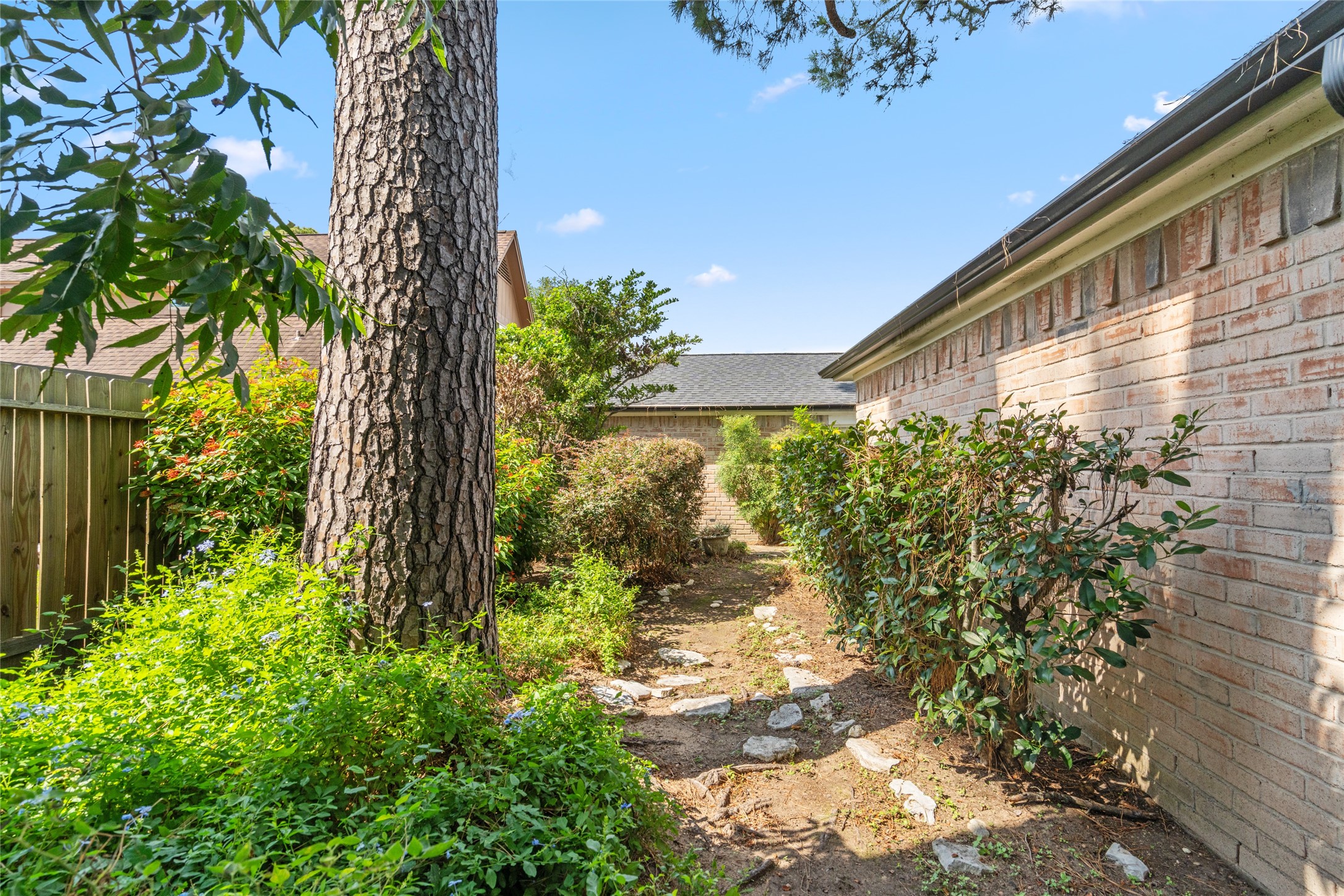 7015 Rosebrook Circle Spring, TX 77379 - Photo 14 of 15 Charming garden path surrounded by lush greenery, mature shade trees, and privacy fencing.