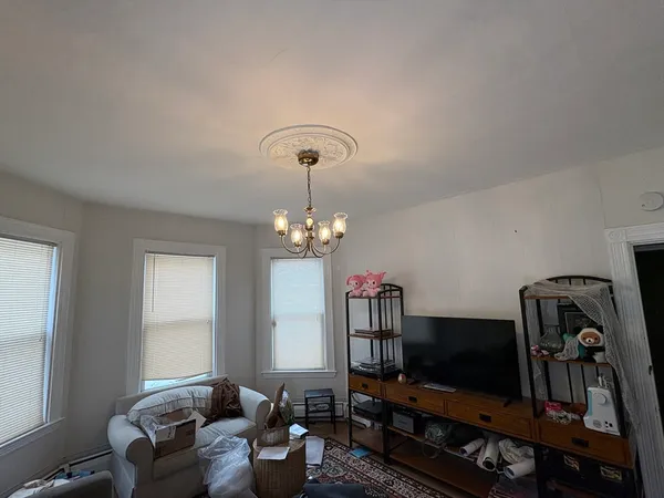 a living room with furniture a flat screen tv and a window