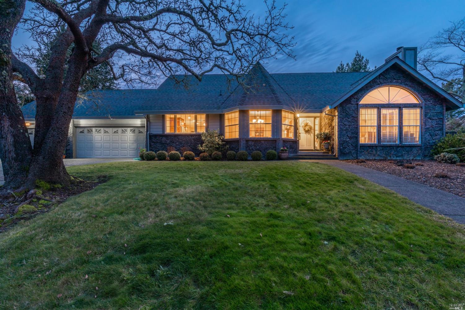 a view of a house with a big yard and large tree