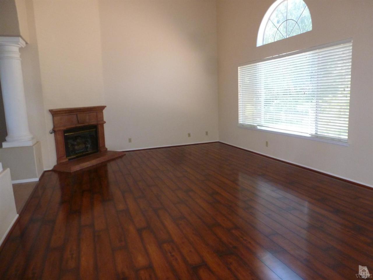 493 Innwood Road Simi Valley, CA 93065 - Photo 11 of 34 an empty room with wooden floor a fireplace and windows