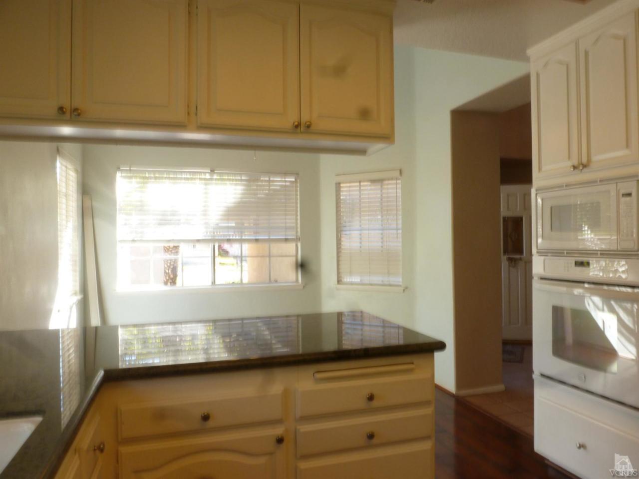 493 Innwood Road Simi Valley, CA 93065 - Photo 18 of 34 a kitchen with granite countertop white cabinets and a refrigerator