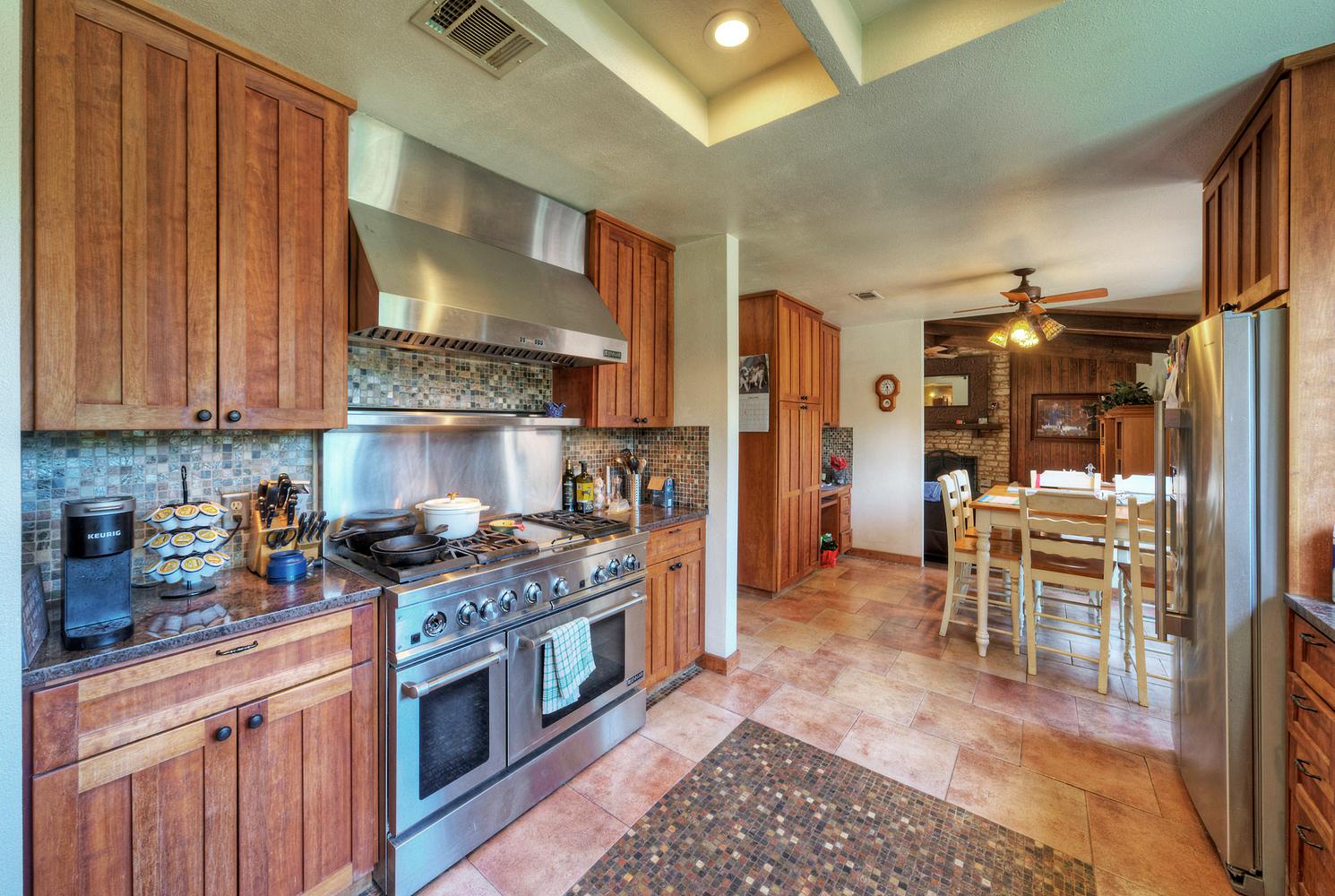 2300 Robin Road Manchaca, TX 78652 - Photo 14 of 36 A spacious culinary layout features rich wood cabinetry and professional-grade stainless steel appliances.