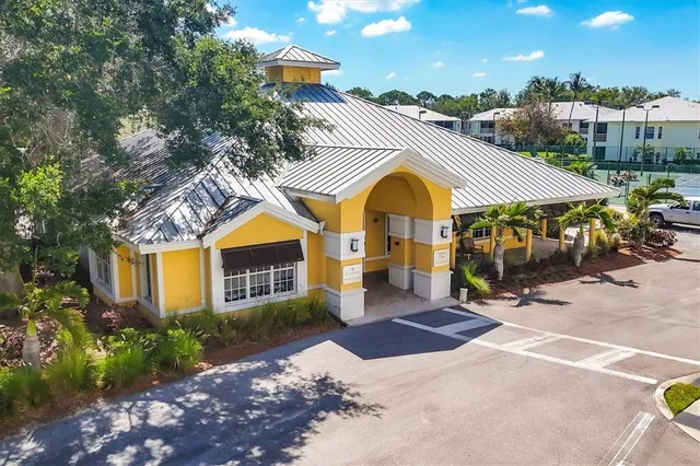 a view of a patio with table and chairs potted plants and floor to ceiling window