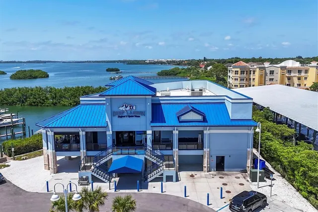 an aerial view of a city with lots of residential buildings and ocean view in back