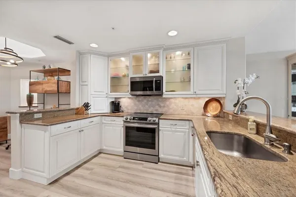 a kitchen with stainless steel appliances granite countertop a sink and stove top oven