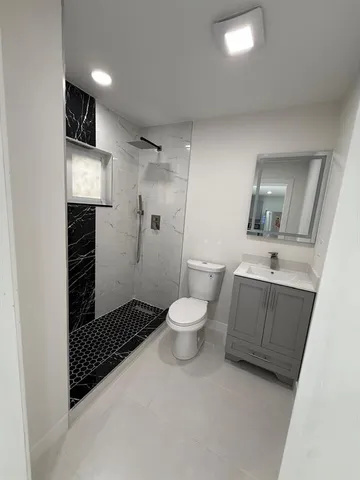a bathroom with a toilet a sink and mirror