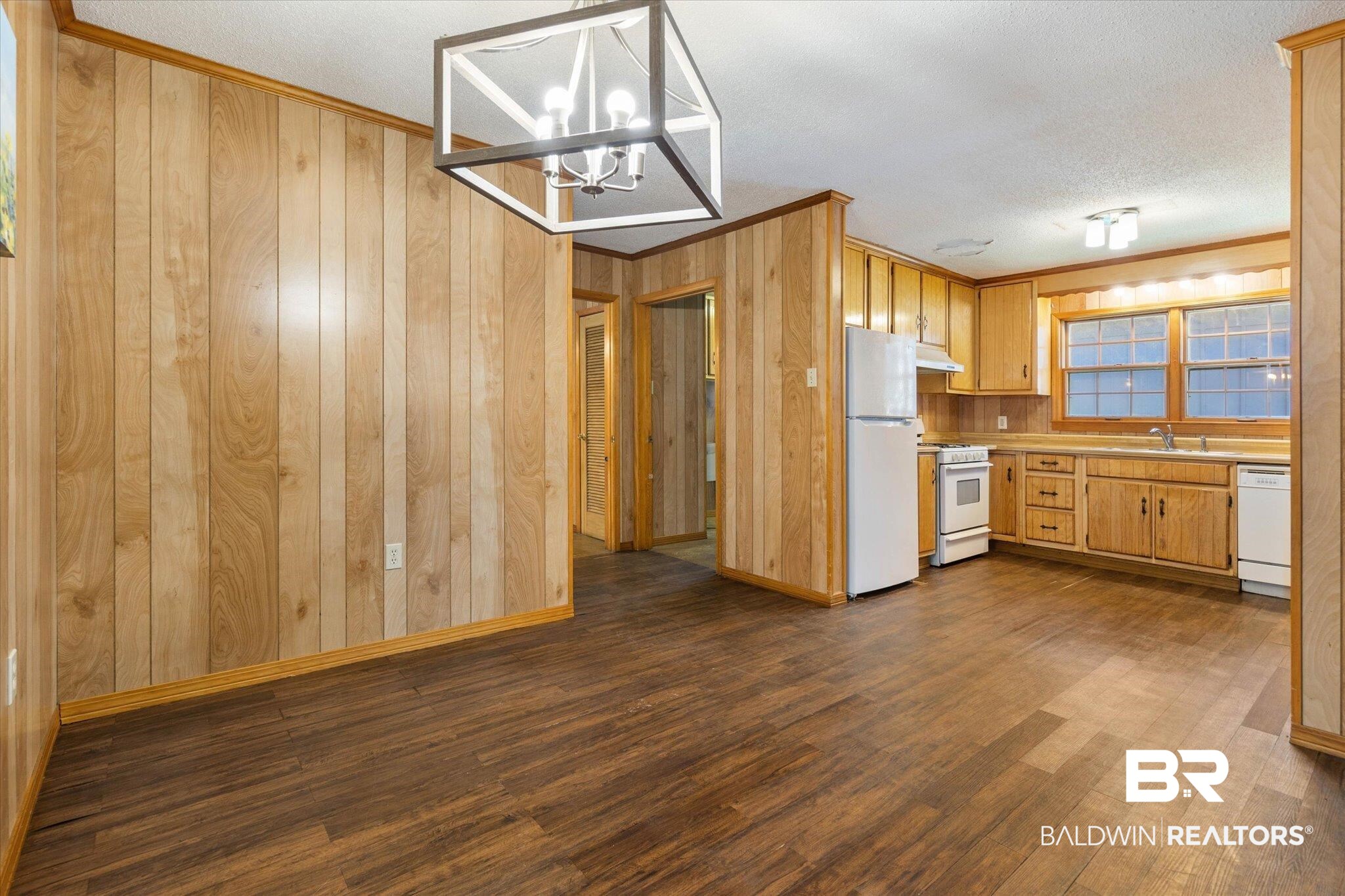 5503 Darring Street Satsuma, AL 36572 - Photo 11 of 31 Kitchen with ornamental molding, light countertops, white appliances, dark wood-style floors, and a chandelier