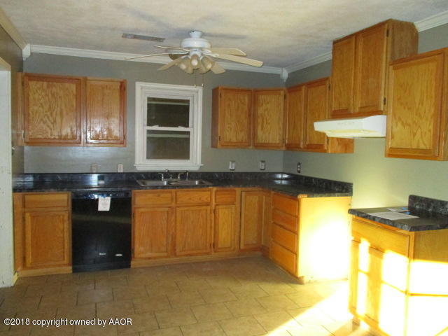 4124 South Lipscomb Street Amarillo, TX 79110 - Photo 11 of 18 a kitchen with granite countertop stainless steel appliances a stove a sink and a microwave