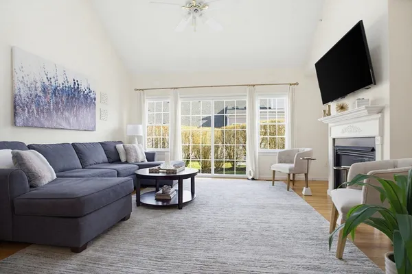 a living room with furniture a flat screen tv and a large window