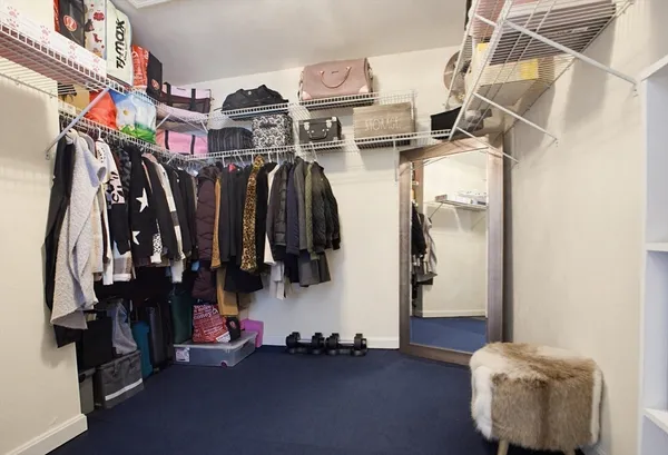a view of walk in closet with clothes and shoes