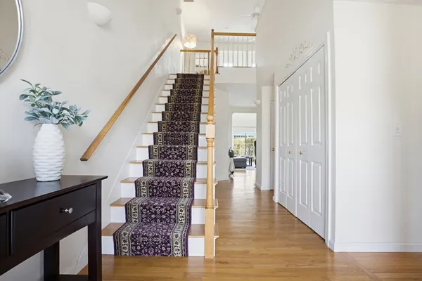 a view of entryway and hall with wooden floor