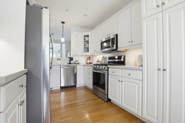 a kitchen with white cabinets and stainless steel appliances