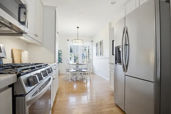 a kitchen with stainless steel appliances granite countertop a refrigerator a stove and a sink