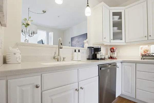 a kitchen with cabinets appliances a sink and a counter top space