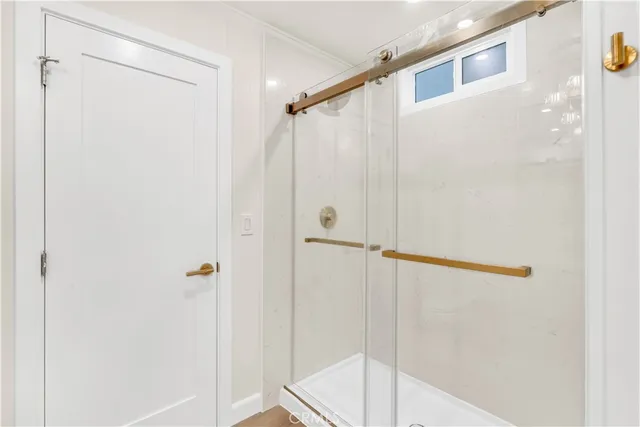 a bathroom with a shower and a glass door