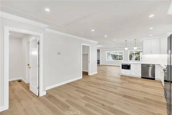 a view of a kitchen with kitchen island a counter top space stainless steel appliances and cabinets