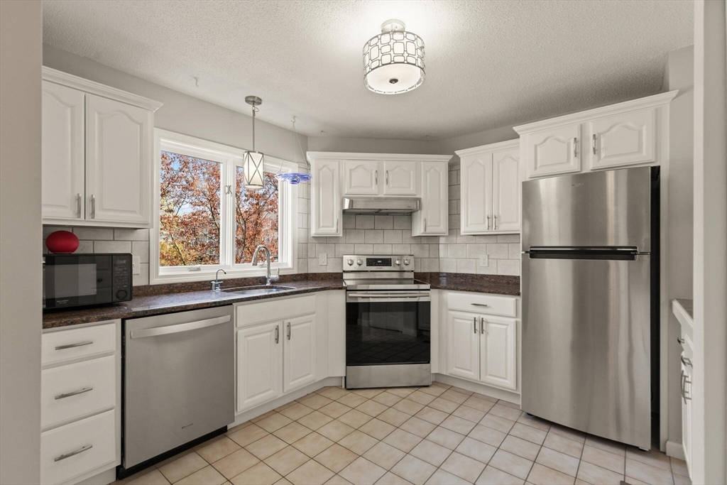 15 Flume Road, Unit 4 Gloucester, MA 01930 - Photo 8 of 41 a kitchen with white cabinets and white appliances
