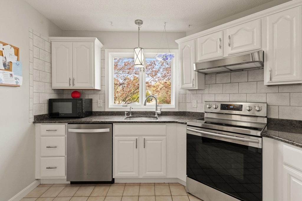 15 Flume Road, Unit 4 Gloucester, MA 01930 - Photo 10 of 41 a kitchen with white cabinets and appliances