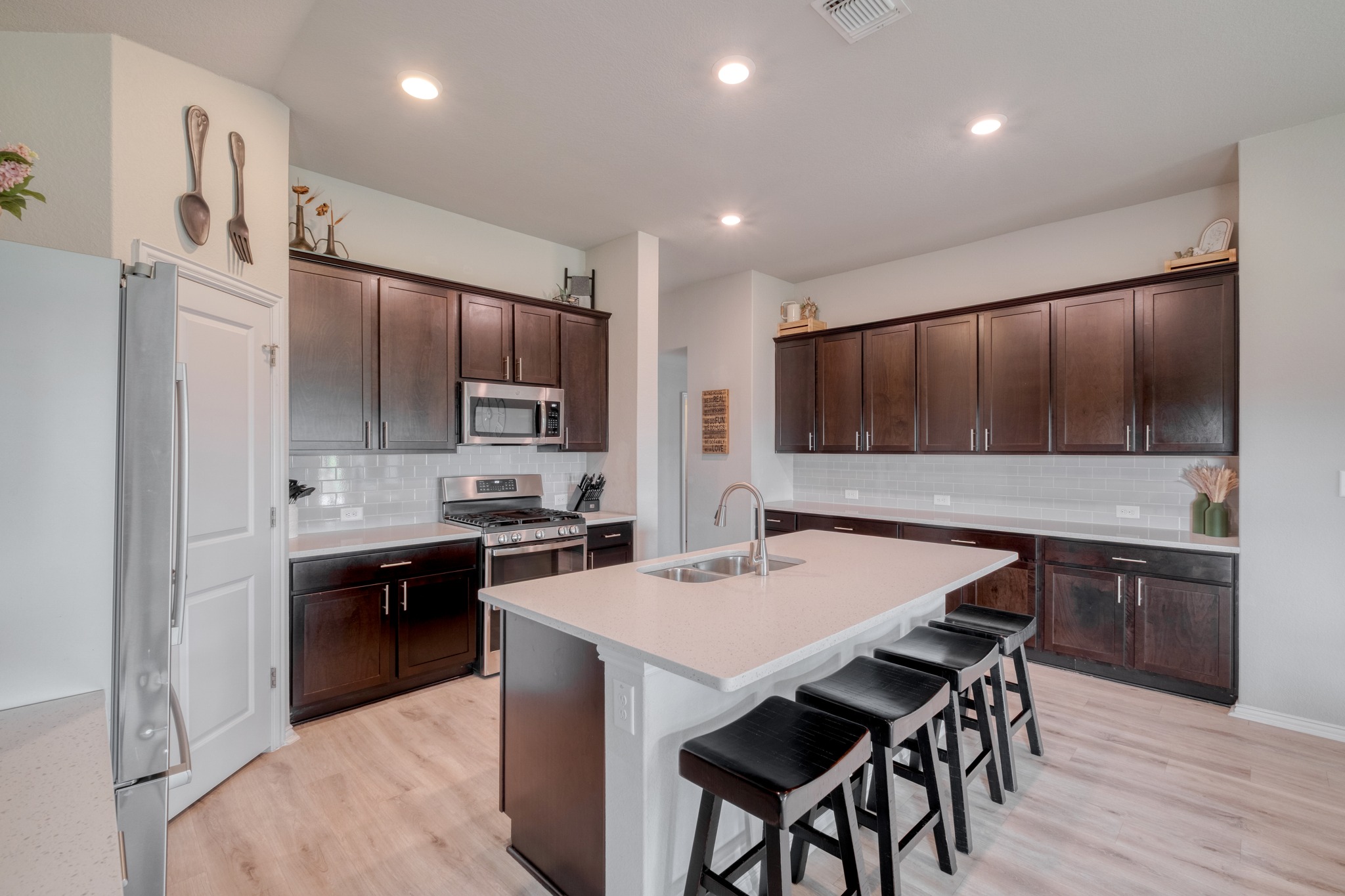 1000 Bright Star Cove Georgetown, TX 78628 - Photo 10 of 40 a kitchen with stainless steel appliances kitchen island granite countertop a stove a sink a refrigerator and a refrigerator